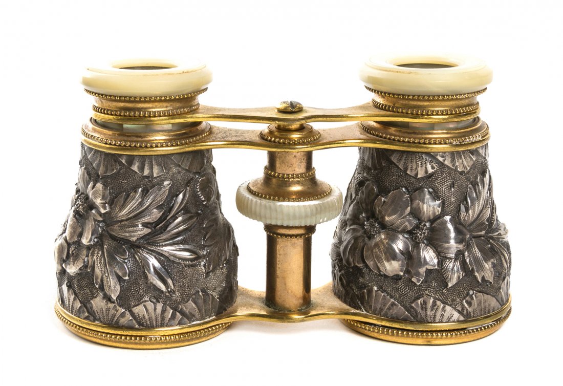 A Pair of French Silvered and Mother-of-Pearl Ven: A Pair of French Silvered and Mother-of-Pearl Veneered Opera Glasses, having foliate relief decoration. Width 4 1/8 inches. Property from the Estate of Mr. Mark Fritz, West Bloomfield, Michigan