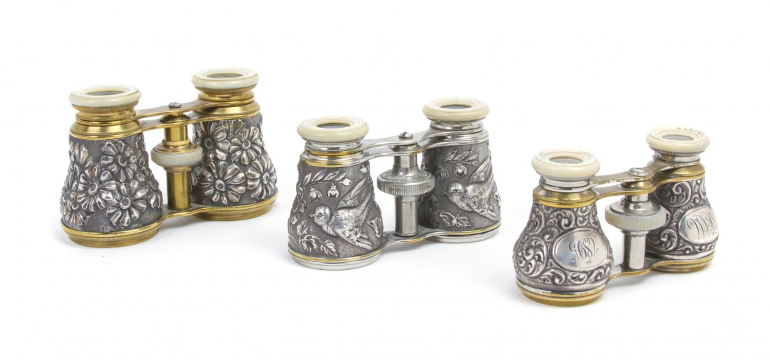 Three Pairs of French Silver and Silvered Opera G: Three Pairs of French Silver and Silvered Opera Glasses, the first by Lemaire with dragonfly decoration, the second by Marchand with a monogram on each cylinder and the last unmarked decorated with fl