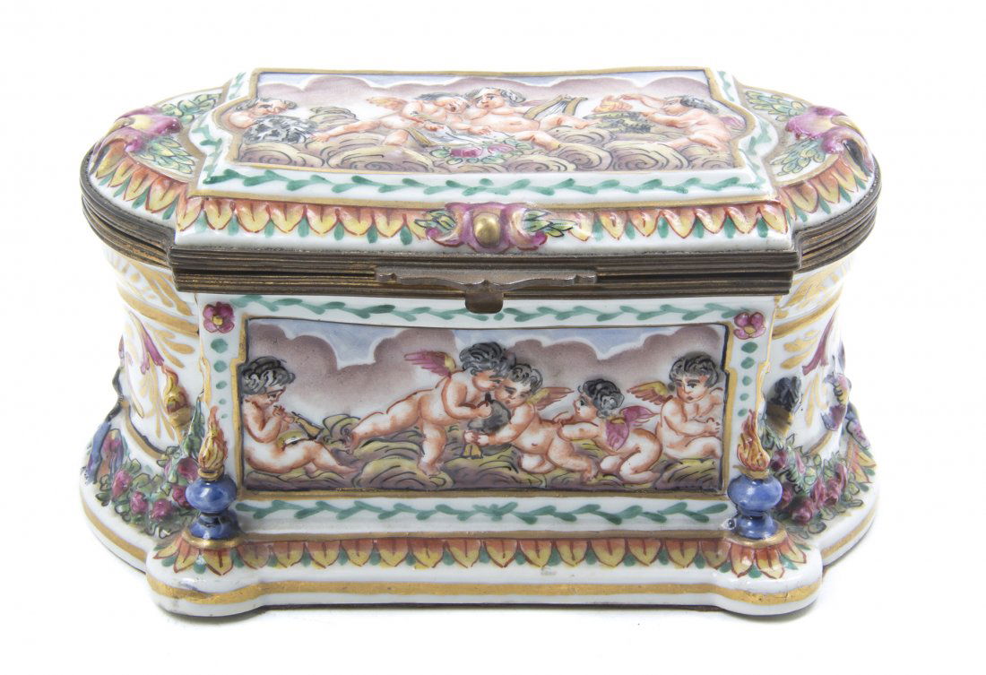 A Capodimonte Porcelain Table Casket, Width 6 1/2 inche: A Capodimonte Porcelain Table Casket, of rectangular form with rounded ends, decorated with putti among clouds. Width 6 1/2 inches.