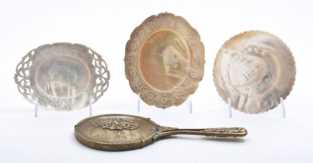 A Collection of Three Carved Abalone Shells, Width of w: A Collection of Three Carved Abalone Shells, of various forms and decorations, together with a gilt metal hand mirror. Width of widest shell 7 1/4 inches.