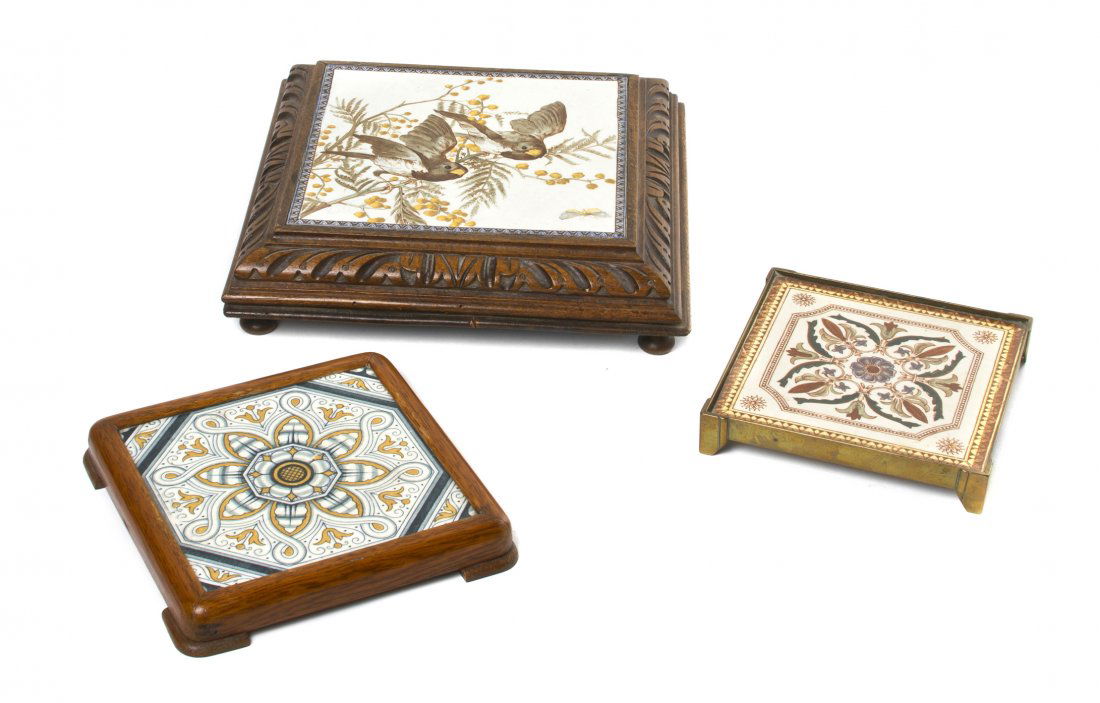 A Collection of Three English Pottery Trivets, Width of: A Collection of Three English Pottery Trivets, the largest decorated with two birds on a flowering branch, set within a musical frame, the smaller two with stylized foliate decoration. Width of first
