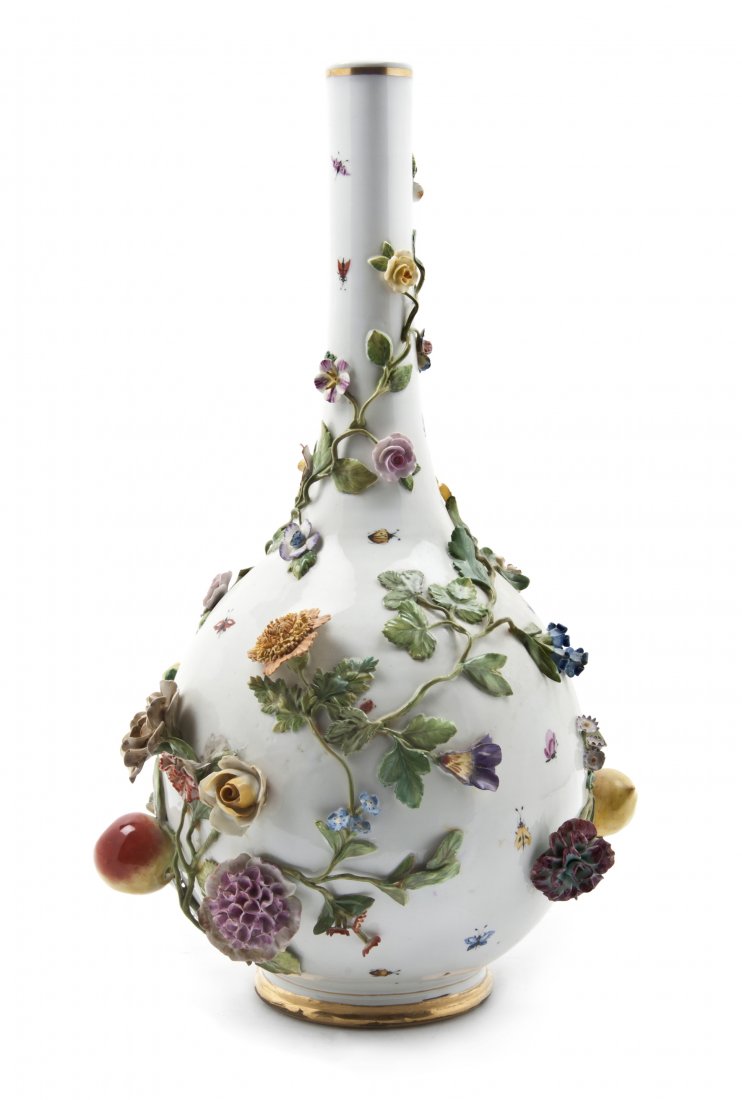 A German Porcelain Vase, Height 17 inches.: A German Porcelain Vase, of bottle form modeled with swirling vines bearing fruit and flowers, further decorated with painted insects and gilt borders. Height 17 inches.