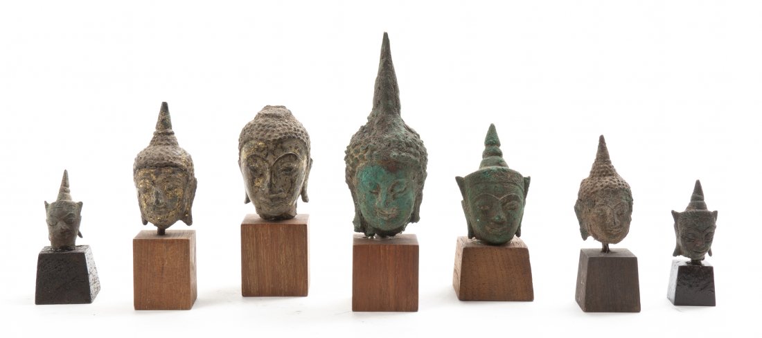 Seven South Asian and Southeast Asian Bronze Buddha Hea: Seven South Asian and Southeast Asian Bronze Buddha Heads, having various patinas, mounted on wood bases. Height of tallest 3 1/2 inches. Property from the Collection of Dr. and Mrs. Sumner Barenberg,