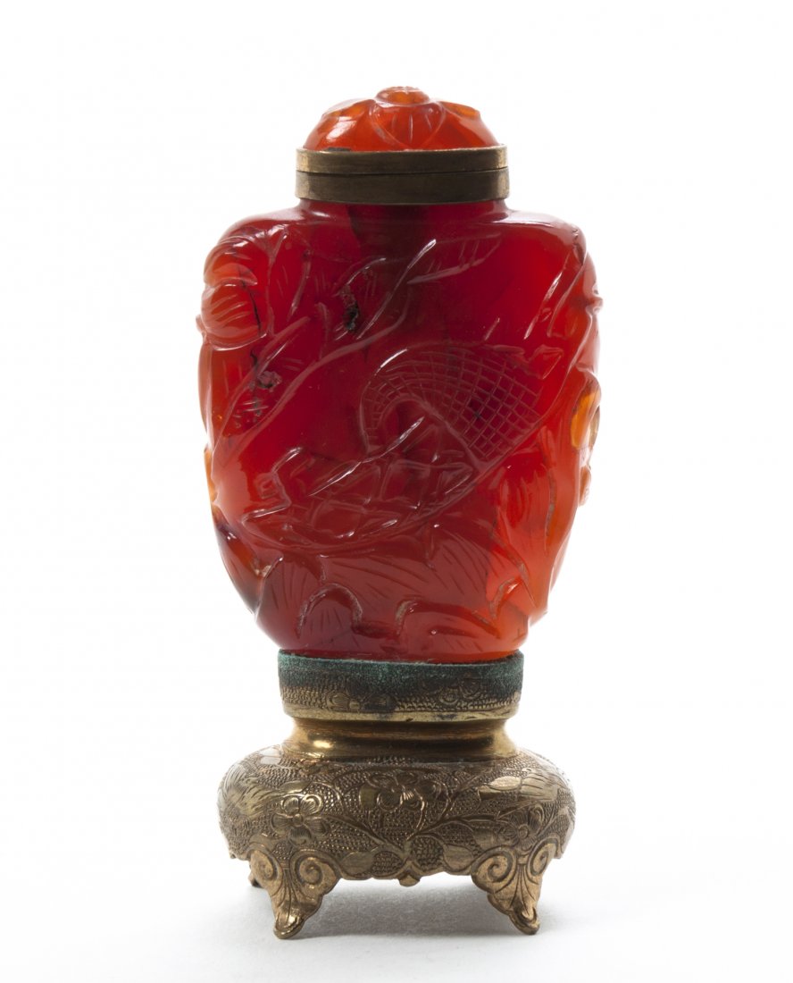 A Carnelian Snuff Bottle, Height overall 3 1/2 inches.: A Carnelian Snuff Bottle, the body having carved decoration of a boat amongst crashing waves, converted to a matchstrike. Height overall 3 1/2 inches.