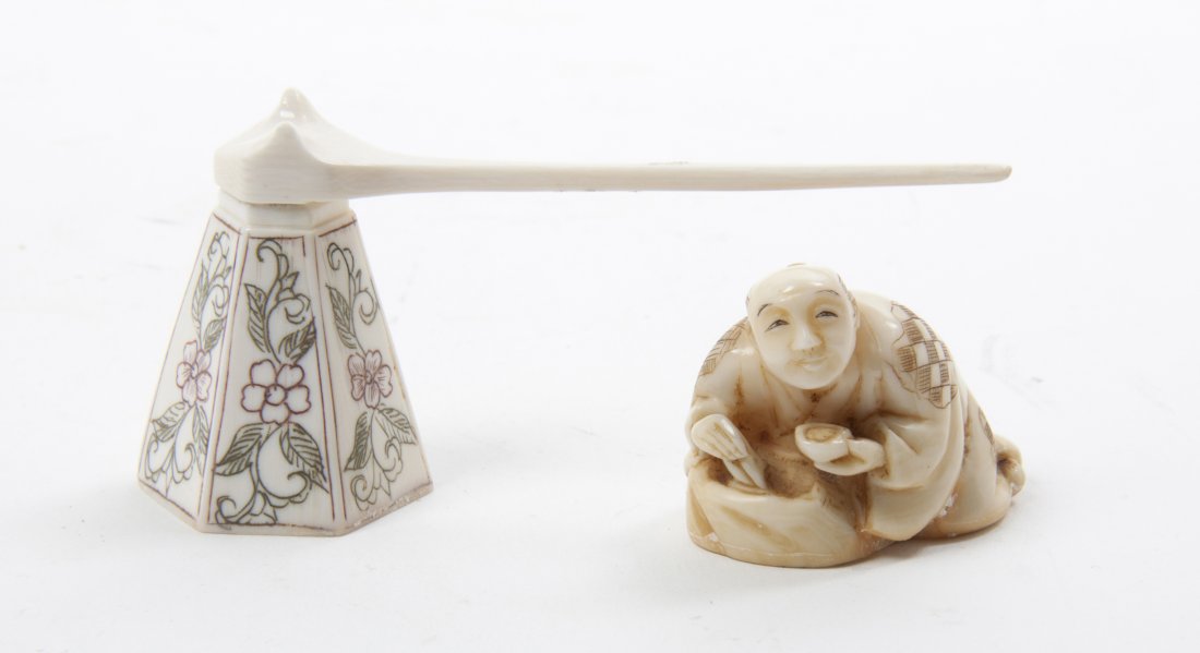 A Japanese Carved Ivory Netsuke, Length of longer 3 1/4: A Japanese Carved Ivory Netsuke, depicting a man crouching at work, together with a polychrome decorated faceted ivory pipe. Length of longer 3 1/4 inches. Property from the Collection of Mr. Larry Wh