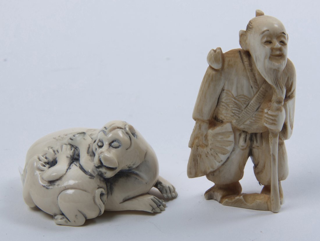 Two Japanese Carved Ivory Articles, Height of tallest 2: Two Japanese Carved Ivory Articles, the first an okimono depicting a peasant with staff and folding fan, the second a composition of two recumbent beasts. Height of tallest 2 1/8 inches. Property from