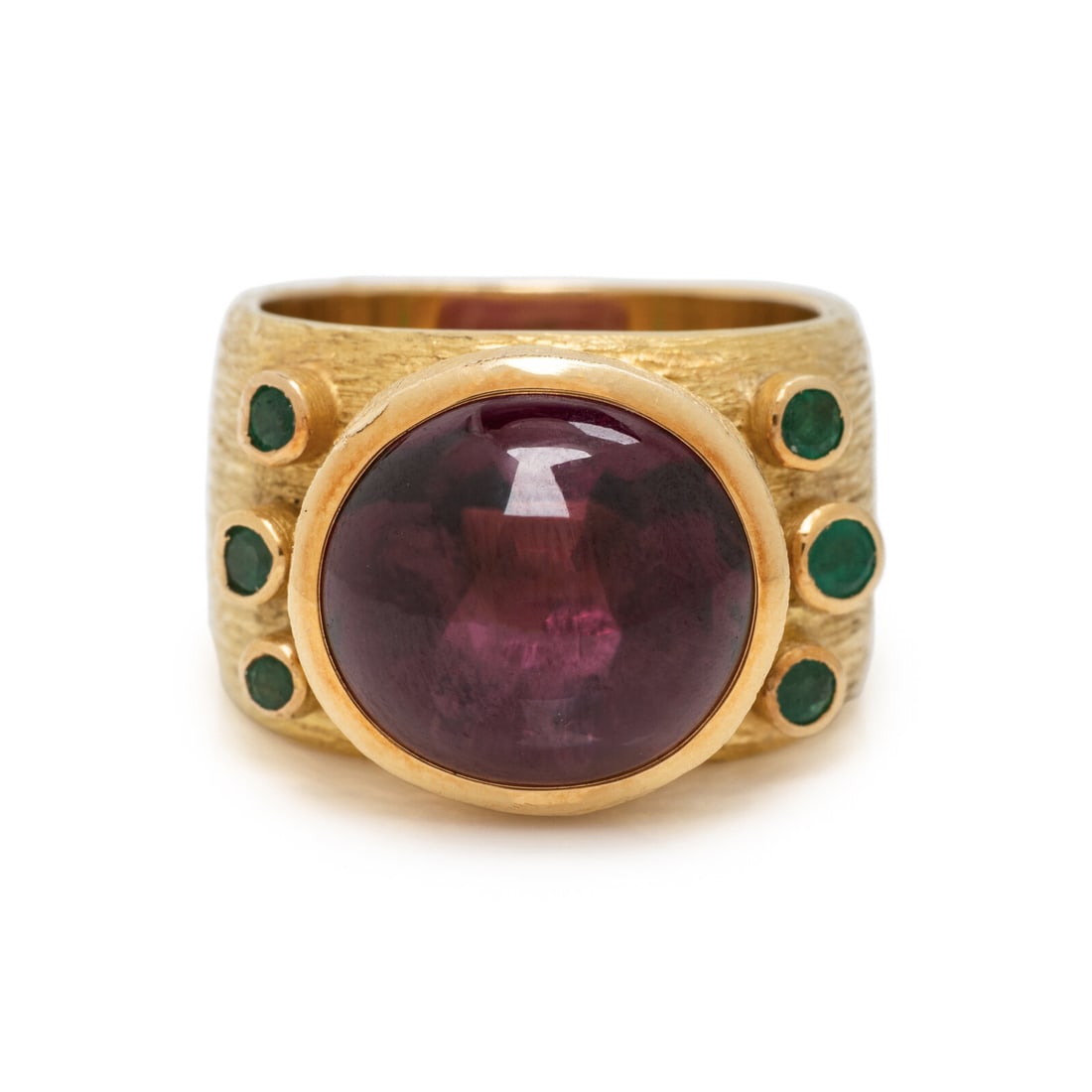 GRIMA, YELLOW GOLD, GARNET, AND EMERALD RING: GRIMA, YELLOW GOLD, GARNET, AND EMERALD RING Set with an oval cabochon garnet measuring approximately 13.15 x 12.20 x 10.60 mm, with round emerald accents. Mounted in textured 18 karat yellow gold. Ri