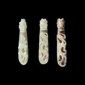 A Chinese 'Chicken-Bone' Jade and Two Pale Celadon Jade 'Dragon' Belt Hooks, Qing Dynasty 清 &