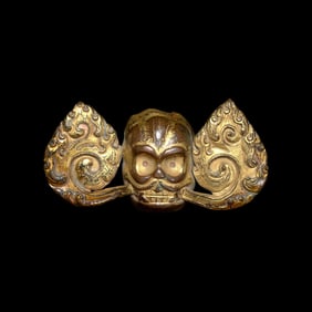 A Tibetan Gilt Copper Alloy Repousse ‘Flaming Skull’ Fitting, 18th/19th Century 十