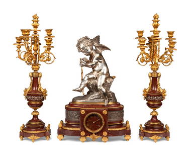 A French Gilt and Silvered Bronze and Rouge Marble Three-Piece Clock Garniture: A French Gilt and Silvered Bronze and Rouge Marble Three-Piece Clock Garniture Late 19th Century comprising a clock and a pair of candelabra; the movement stamped 'Lemerle Charpentier Fdr de Bronzes/
