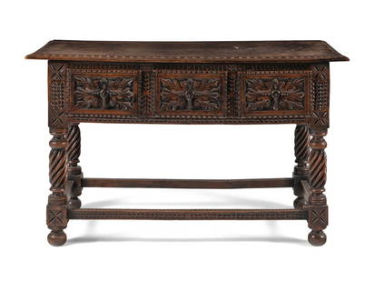 A Jacobean Style Carved Walnut Console Table: A Jacobean Style Carved Walnut Console Table 20th Century the frieze set with three drawers. Height 33 1/2 x width 55 x depth 25 inches. This lot is located in Chicago.