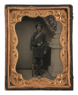 [CIVIL WAR]. Tintype portrait of a doubly armed soldier in full kit. : [CIVIL WAR]. Tintype portrait of a doubly armed soldier in full kit. Quarter plate full standing studio portrait of a Union soldier with long hair and mustache, wearing a his cartridge sling and