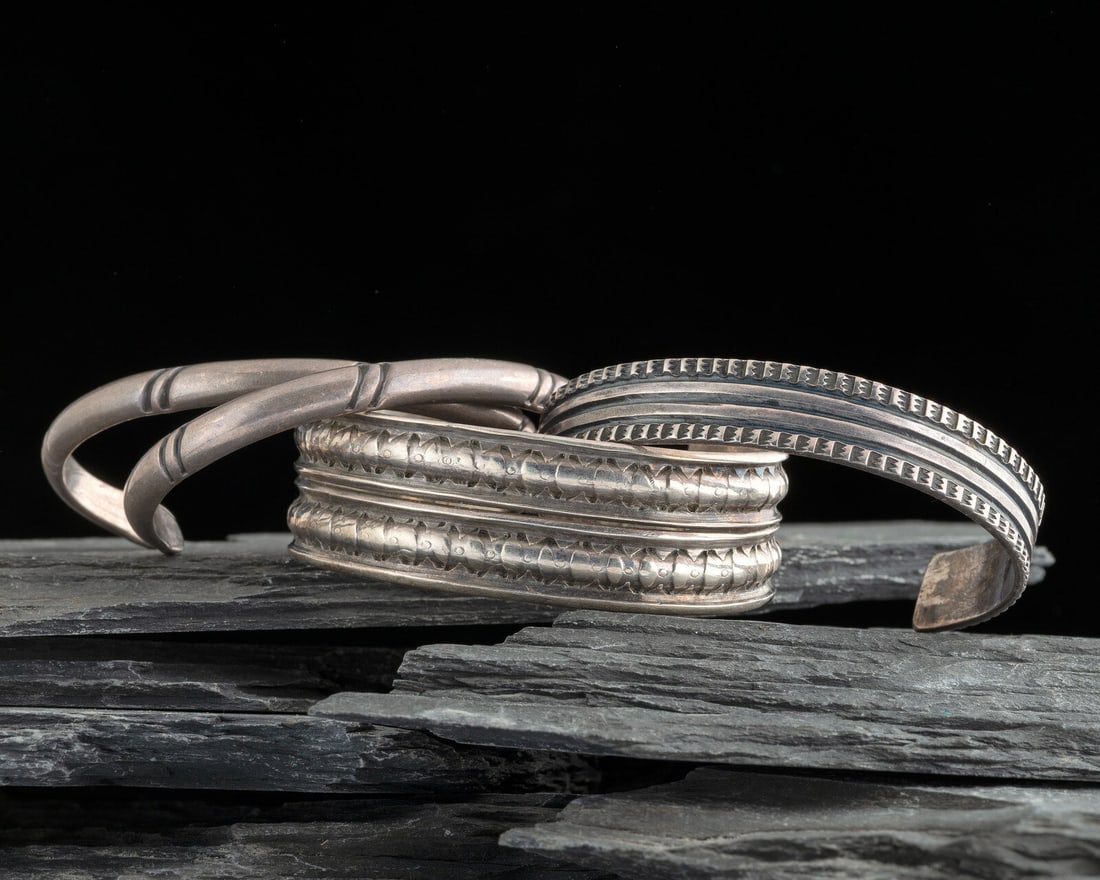 Group of Slender Navajo Ingot Cuff Bracelets: Group of Slender Navajo Ingot Cuff Bracelets first quarter 20th century lot of 4, all are unmarked, includes: an example with chiseled central line and stamping along the edge cuff width 1/2 inch, int