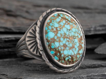 Navajo Silver and #8 Turquoise Ring: Navajo Silver and #8 Turquoise Ring second quarter 20th century split shank ring with chiseled apliquéd designon sides; set with a single stone in a rope bezel; not marked size 10.25, weight 7.9