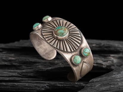 Navajo Ingot and Turquoise Cuff Bracelet: Navajo Ingot and Turquoise Cuff Bracelet the shank, decorated with light repoussé on either side; set with five turquoise stones, the central stone set in a chiseled radiating design; not marked