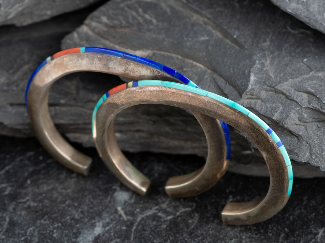 Jimmie King, Jr. (Diné, d. 2017) Pair of Slender Sterling Silver Cuff Bracelets, with Inlay: Jimmie King, Jr. (Diné, d. 2017) Pair of Slender Sterling Silver Cuff Bracelets, with Inlay lot of 2, both signed and marked STERLING, includes: one primarily set with lapis and accented with tur