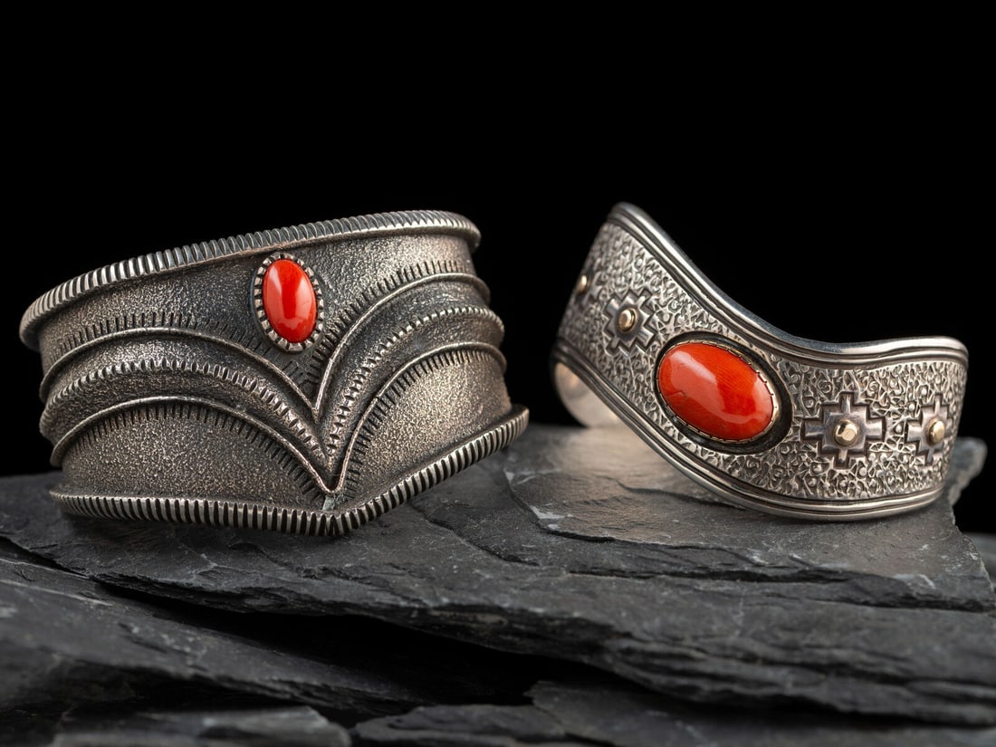 Navajo Silver and Coral Cuff Bracelets: Navajo Silver and Coral Cuff Bracelets late 20th - early 21st century lot of 2, includes: a tufa cast example with taper shank and set with a single coral cabochon; attributed to Harrison Jim (act. si