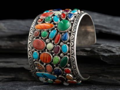 Navajo Sterling Silver Cluster Cuff Bracelet: Navajo Sterling Silver Cluster Cuff Bracelet late 20th century set with a variety of stones in differing shapes and sizes, including turquoise, coral, spiny oyster, opal, lapis, malachite, and gaspite