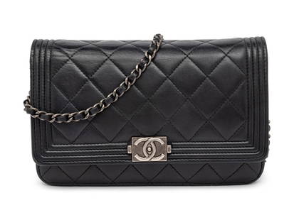 CHANEL, BOY WALLET ON CHAIN: CHANEL, BOY WALLET ON CHAIN Chanel Boy Wallet on Chain in quilted black leather with aged ruthenium hardware. Snap closure and interwoven leather-metal chain strap. Label: Chanel Code: 19419404