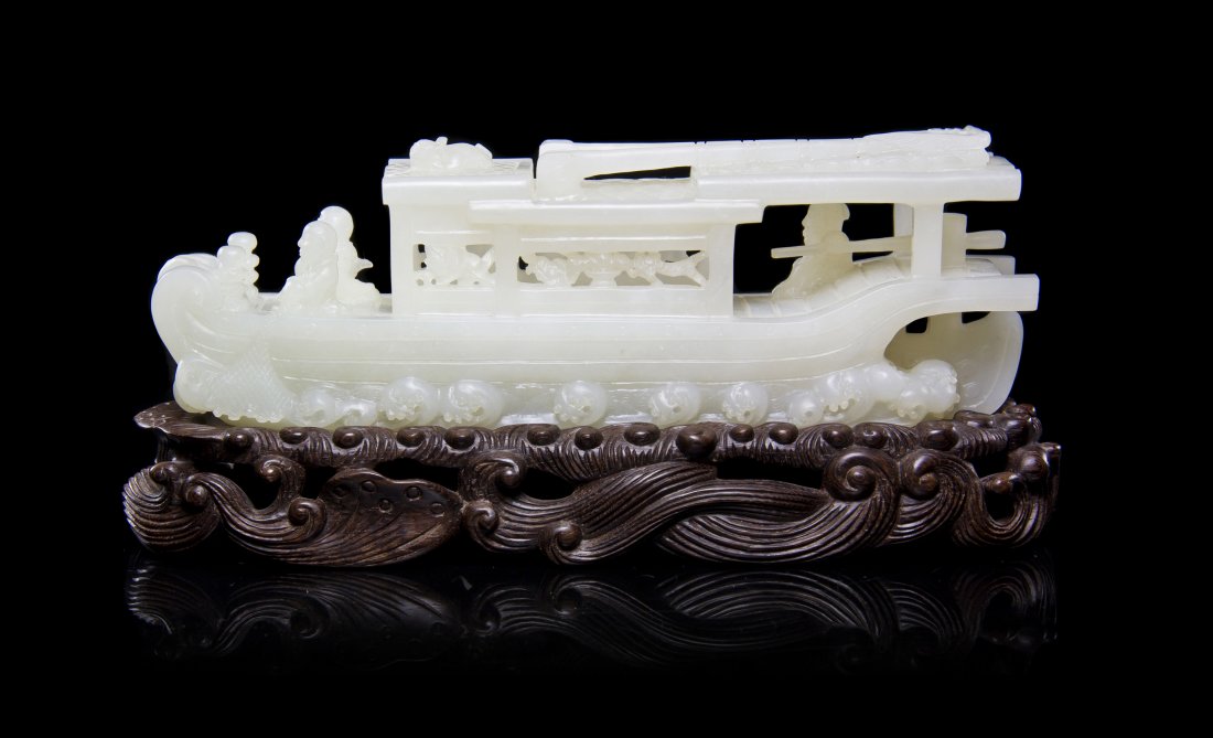 A Carved White Jade Model of a Boat, Width 7 5/8 inches: A Carved White Jade Model of a Boat, the vessel holding multiple passengers at the fore and aft, having pierce carved, paneled interior cabin and incised details to the deck and roof, having curled wa