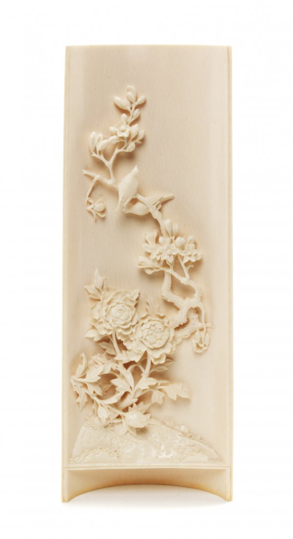 A Chinese Carved Ivory Wrist Rest, Height 9 3/8 inches.: A Chinese Carved Ivory Wrist Rest, of rounded rectangular form decorated with a flowering branch of peonies climbing up the hollowed reserve, a bird perched near the tip of the branch. Height 9 3/8 in