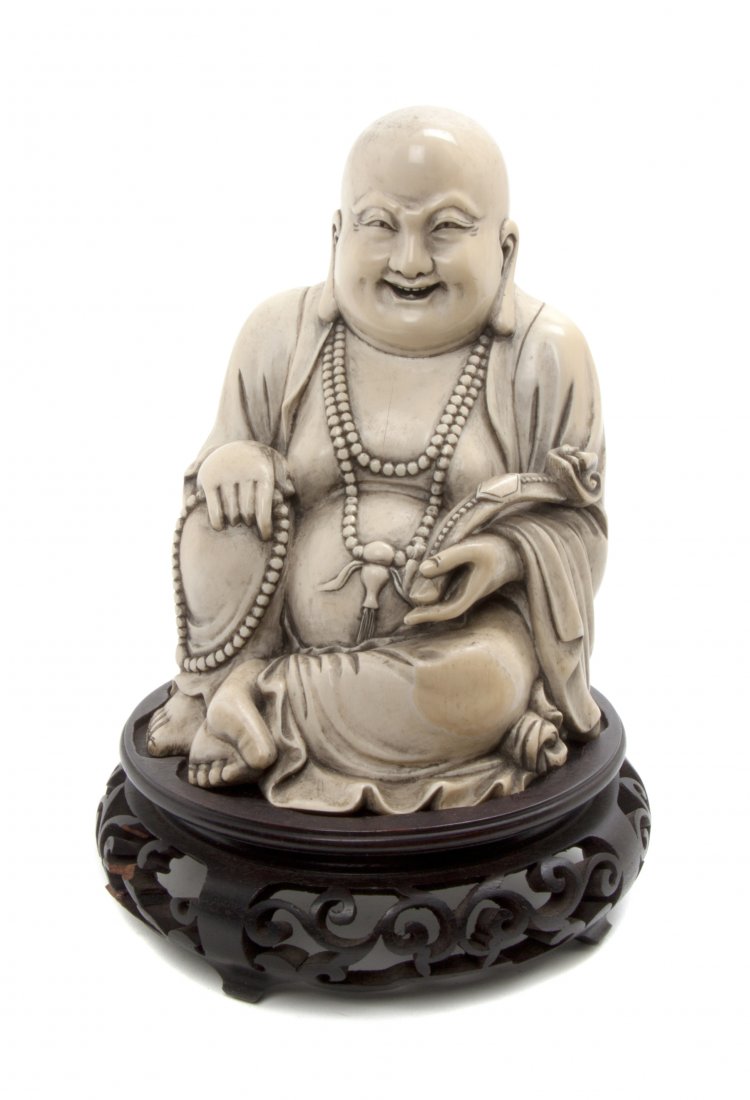 A Chinese Carved Ivory Buddha, Height 7 1/8 inches.: A Chinese Carved Ivory Buddha, the smiling, rotund deity depicted seated in draped robes with a long mala necklace around his neck and another in his right hand, a ruyi scepter in the other, raised on