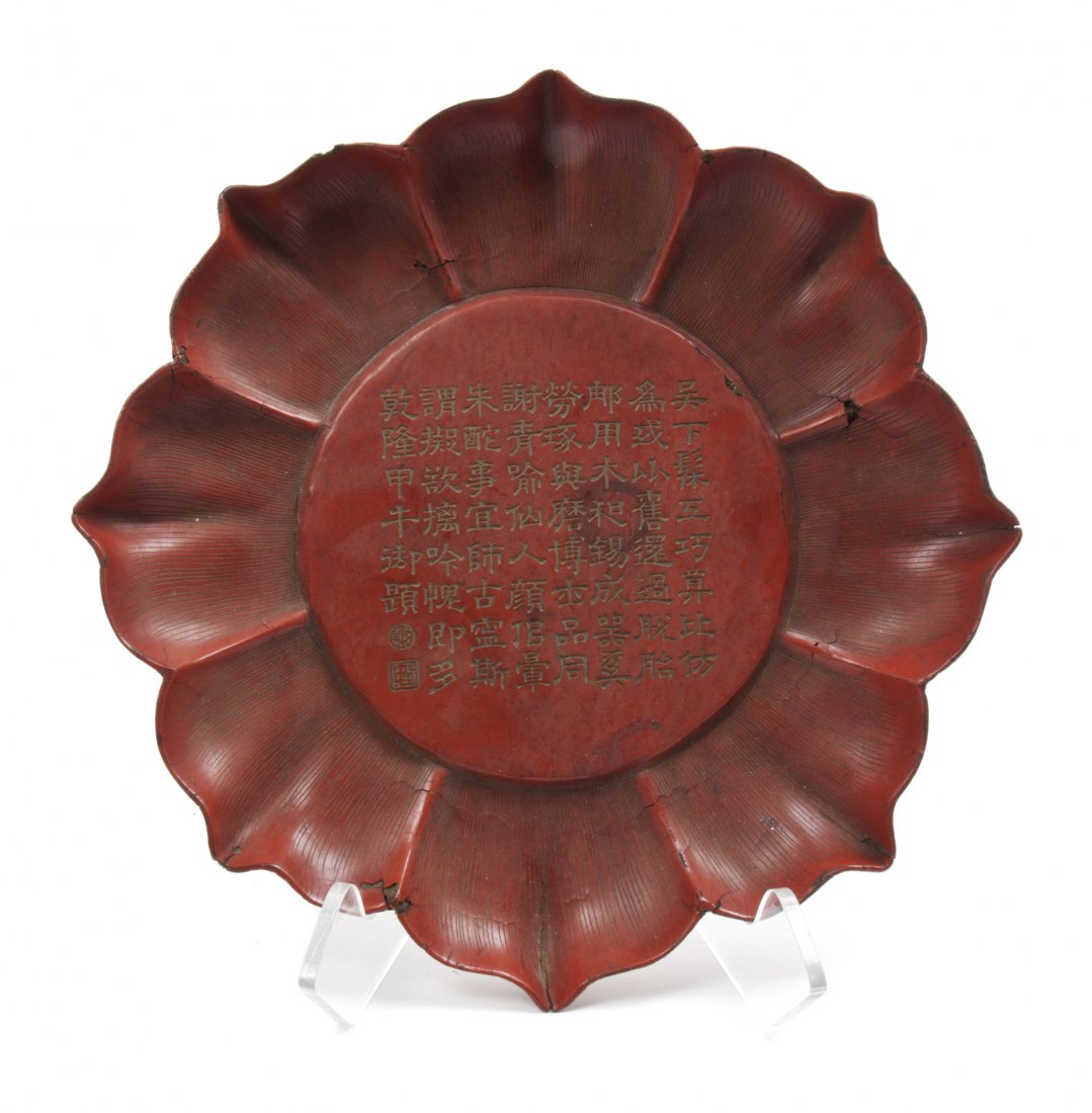 A Chinese Cinnabar Lacquer Plate, Diameter 9 3/4 inches: A Chinese Cinnabar Lacquer Plate, of floriform, the center with calligraphic inscription. Diameter 9 3/4 inches.