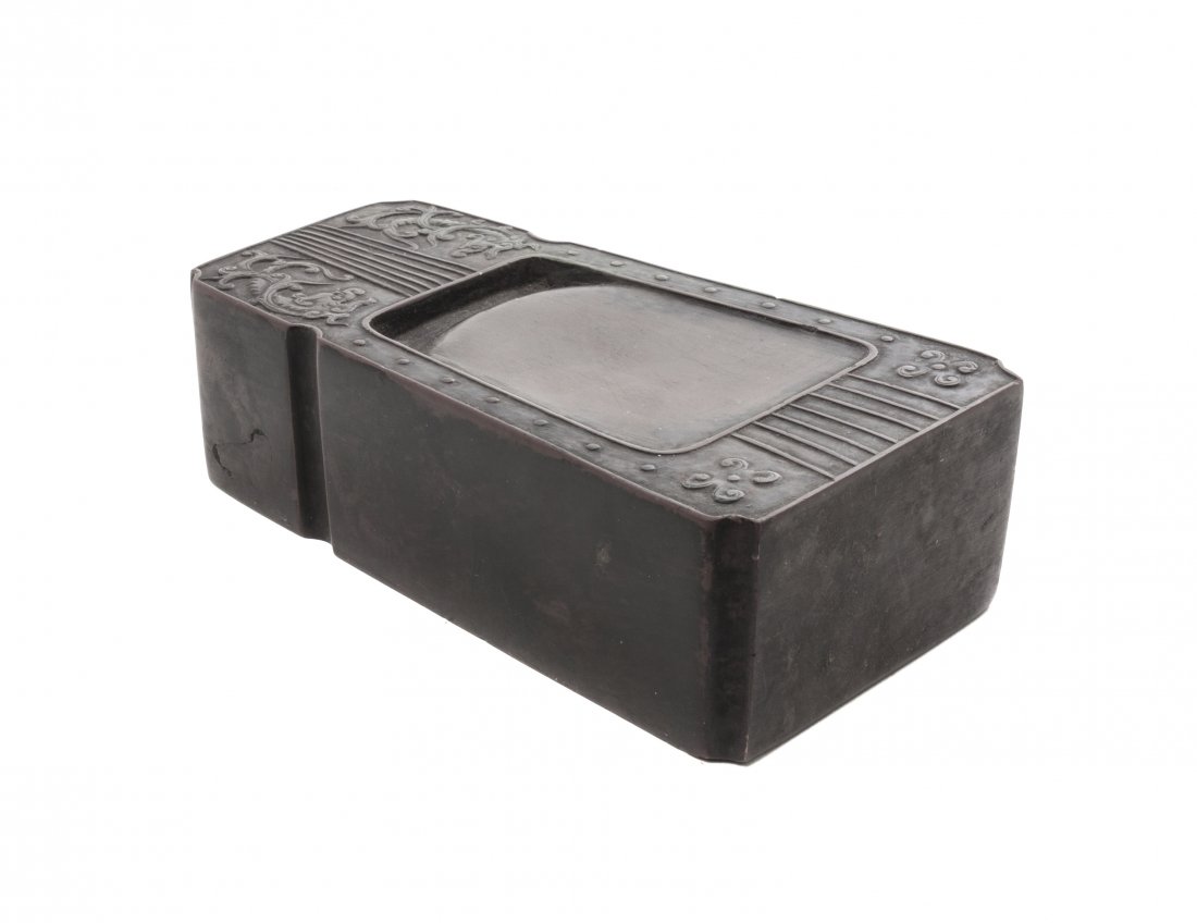 A Chinese Inkstone, Width 5 1/8 inches.: A Chinese Inkstone, in the form of a guzheng, having relief decoration of opposing qilong on either side of seven raised stripes along the center of the stone. Width 5 1/8 inches.