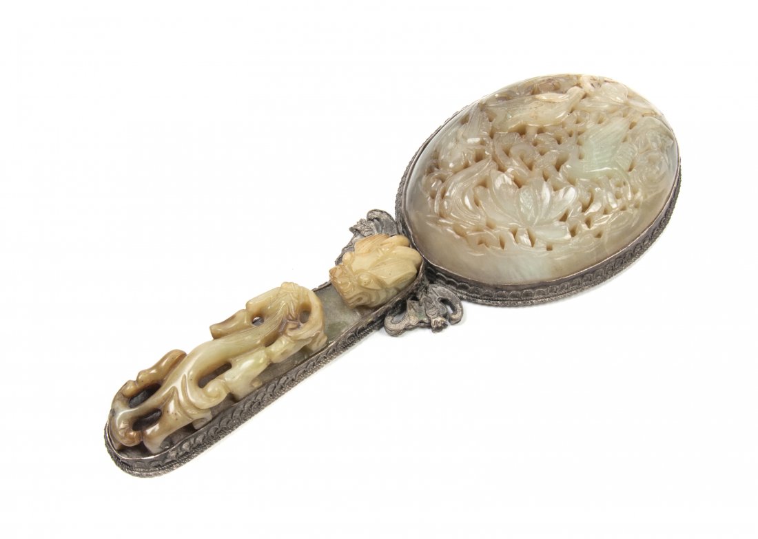 A Chinese Hand Mirror, Length overall 9 1/4 inches.: A Chinese Hand Mirror, the circular glass backed with a near-white jade pierce carved plaque, the handle set with a yellow mottled jade carved belthook. Length overall 9 1/4 inches.