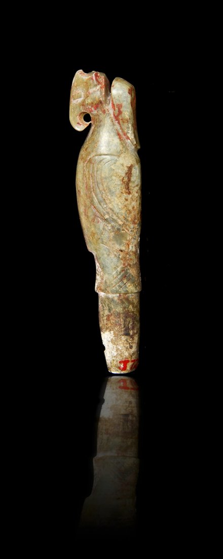 An Archaic Jade Bird-Form Carving, Length 3 inches.: An Archaic Jade Bird-Form Carving, Shang Dynasty, of a mottled celadon colored stone with areas of calcification, the tapering toggle surmounted by the bird depicted with wings folded down the sides, 