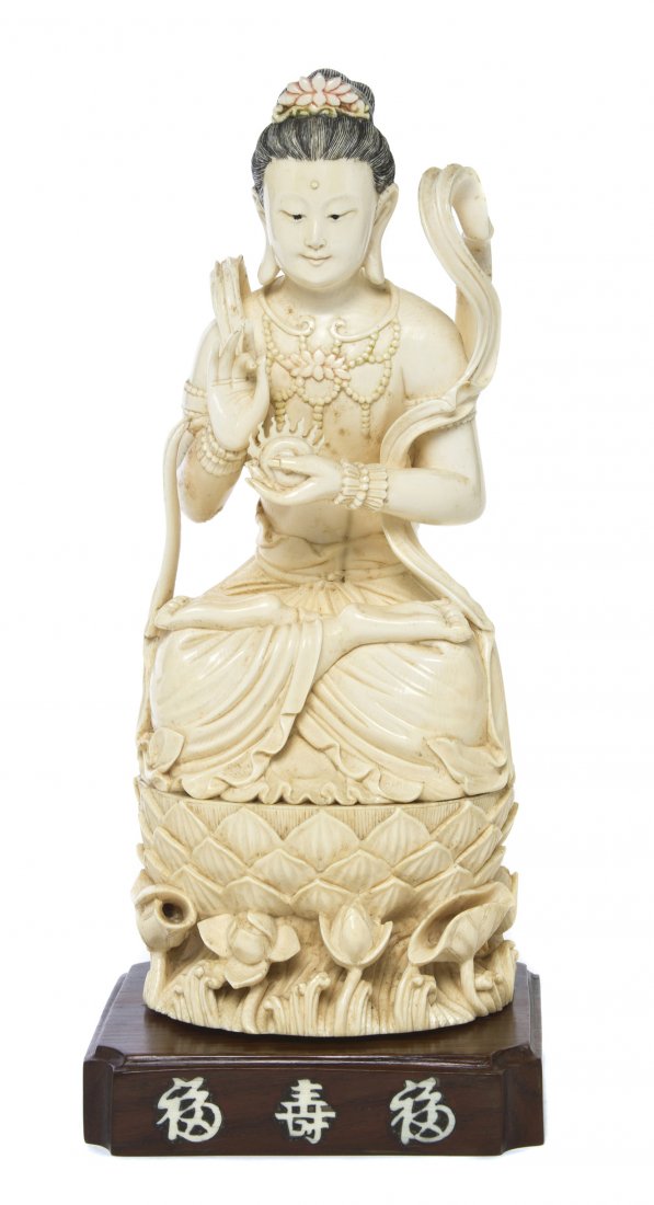 A Chinese Carved Ivory Figure of a Buddhist Deity, Heig: A Chinese Carved Ivory Figure of a Buddhist Deity, depicted with a lotus flower adorning the ushnisha, wearing flowing sashes and an openwork beaded necklace centered with a lotus blossom, shown holdi