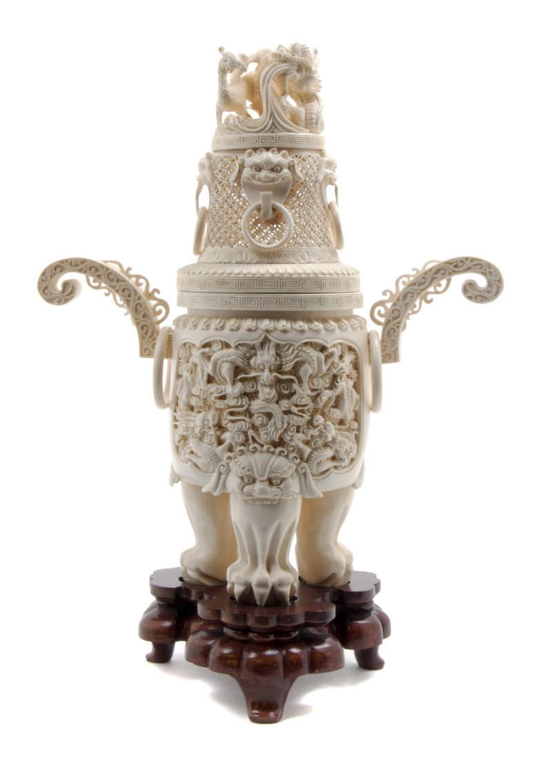 A Chinese Carved Ivory Censer, Height 14 1/2 inches.: A Chinese Carved Ivory Censer, the lid surmounted with a crouching dragon above free-moving rings issued from lion's masks, the circular body having relief carved reserves and flanked by scrolled arms