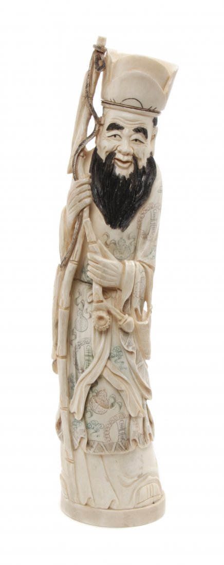 A Chinese Carved Ivory Figure of a Sage, Height 12 inch: A Chinese Carved Ivory Figure of a Sage, the figure depicted standing with a bamboo staff, his eyebrows and beard stained, his robes with polychrome decoration. Height 12 inches.