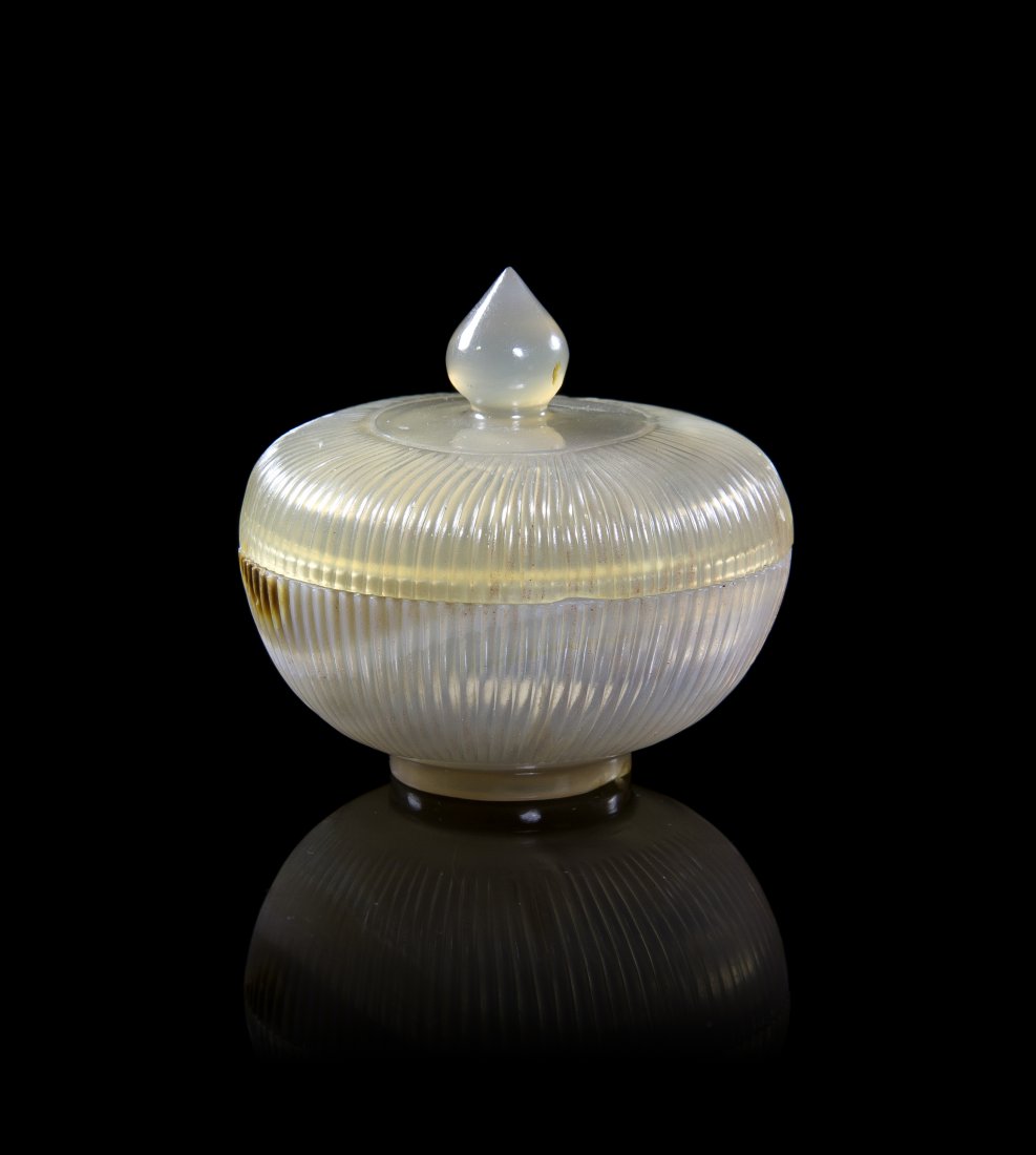 A Chinese Mughal Carved Agate Lidded Bowl, Diameter 2 1: A Chinese Mughal Carved Agate Lidded Bowl, the ribbed bowl and cover surmounted with a knop finial, raised on a circular foot ring. Diameter 2 1/2 inches. Property from the Estate of Mr. Frank Buttram