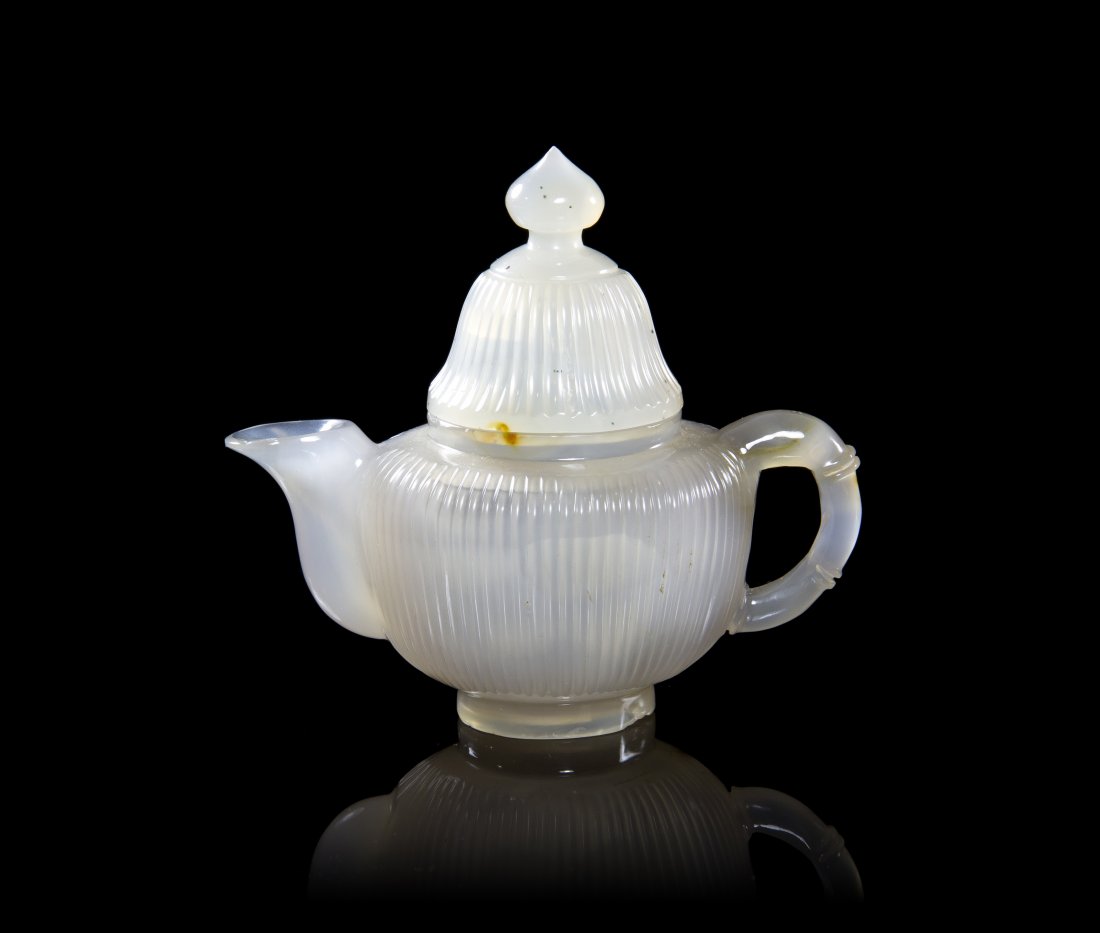 A Chinese Mughal Carved Agate Teapot, Height 3 5/8 inch: A Chinese Mughal Carved Agate Teapot, the ribbed body and cover surmounted with a knop finial, having a single openwork handle and curved spout, raised on a circular foot ring. Height 3 5/8 inches. Pr