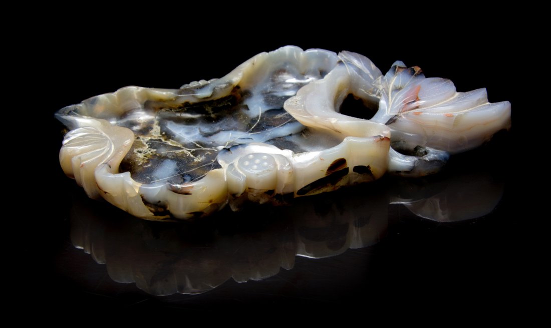 A Carved Agate Brush Washer, Width 6 1/2 inches.: A Carved Agate Brush Washer, of leaf form with lotus root, blossoms and leaves carved to the curled sides. Width 6 1/2 inches.