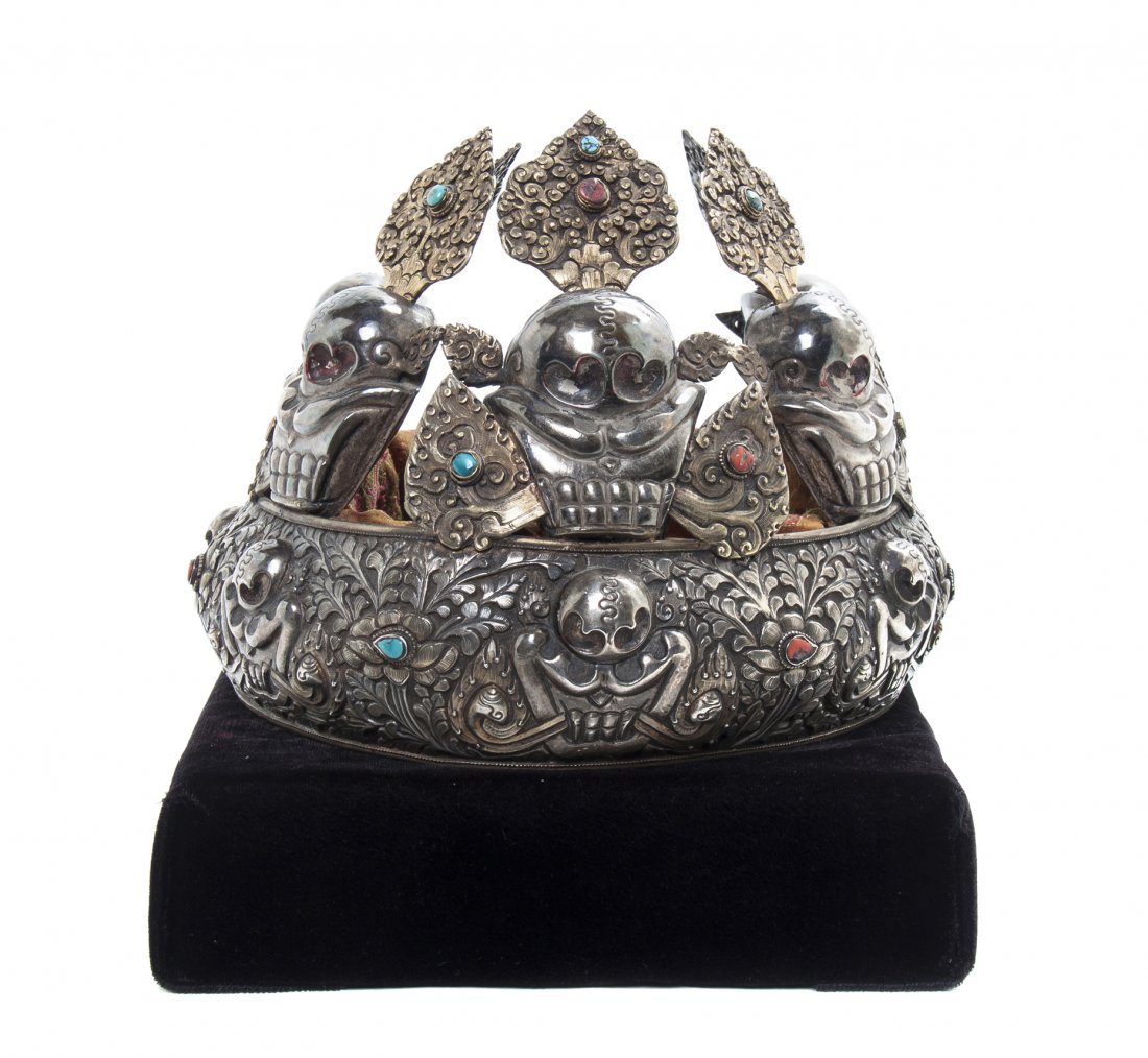 An Inset Silver Tibetan or Nepalese Oracle Crown, Width: An Inset Silver Tibetan or Nepalese Oracle Crown, of semi-circular form having repousse decoration depicting floral sprays and scrolling leaves interspersed with domed accents, inset with turquoise an