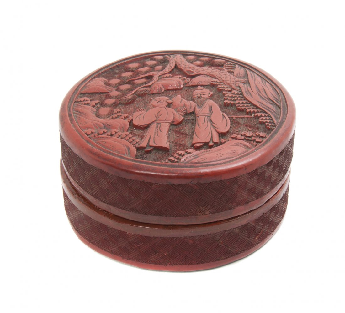 A Cinnabar Lacquered Circular Covered Box, Diameter 4 i: A Cinnabar Lacquered Circular Covered Box, having relief carved figural decoration to the cover and diaper pattern covered sides. Diameter 4 inches.