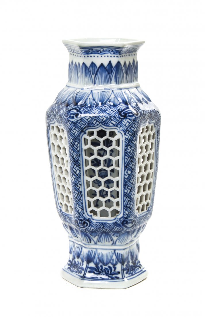 A Chinese Blue and White Porcelain Vase, Height 8 3/4 i: A Chinese Blue and White Porcelain Vase, of hexagonal baluster form, with lotus petal decoration and wan patterned ground, each facet pierced revealing an interior vessel with floral decoration, unmar