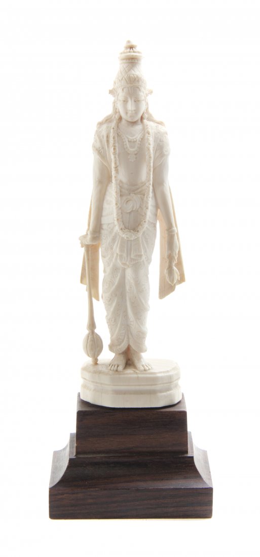 An Indian Carved Ivory Figure of Krishna, Height 6 inch: An Indian Carved Ivory Figure of Krishna, depicted standing in draped garments and jewelry, raised upon a faceted base, further raised on a tiered wood base. Height 6 inches. Property from the Collect