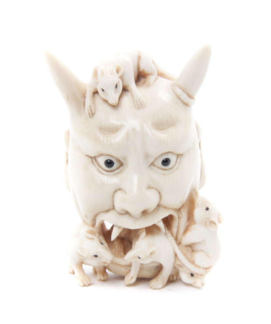 A Japanese Carved Ivory Netsuke, Height 1 5/8 inches.: A Japanese Carved Ivory Netsuke, depicting the head of an oni with four mice, bearing mother-of-pearl signature plaque to the back. Height 1 5/8 inches. Property from the Collection of Mr. and Mrs. Jo