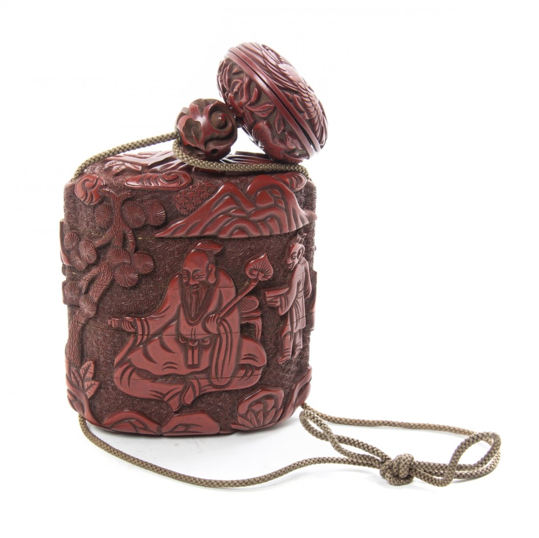 A Japanese Cinnabar Lacquered Inro, Height 3 5/8 inches: A Japanese Cinnabar Lacquered Inro, of square form having five tiers, one side depicting a figure with two attendants in a mountain landscape against a patterned ground, the reverse depicting a schola