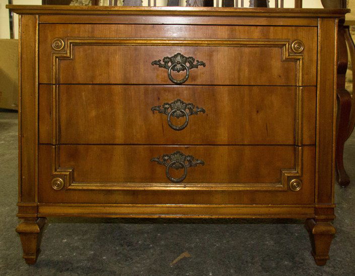 A Walnut and Parcel Gilt Chest of Drawers, John Widdico: A Walnut and Parcel Gilt Chest of Drawers, John Widdicomb, having a rectangular top over three drawers with ring handles, raised on square tapering feet. Height 24 x width 30 x depth 17 3/4 inches.