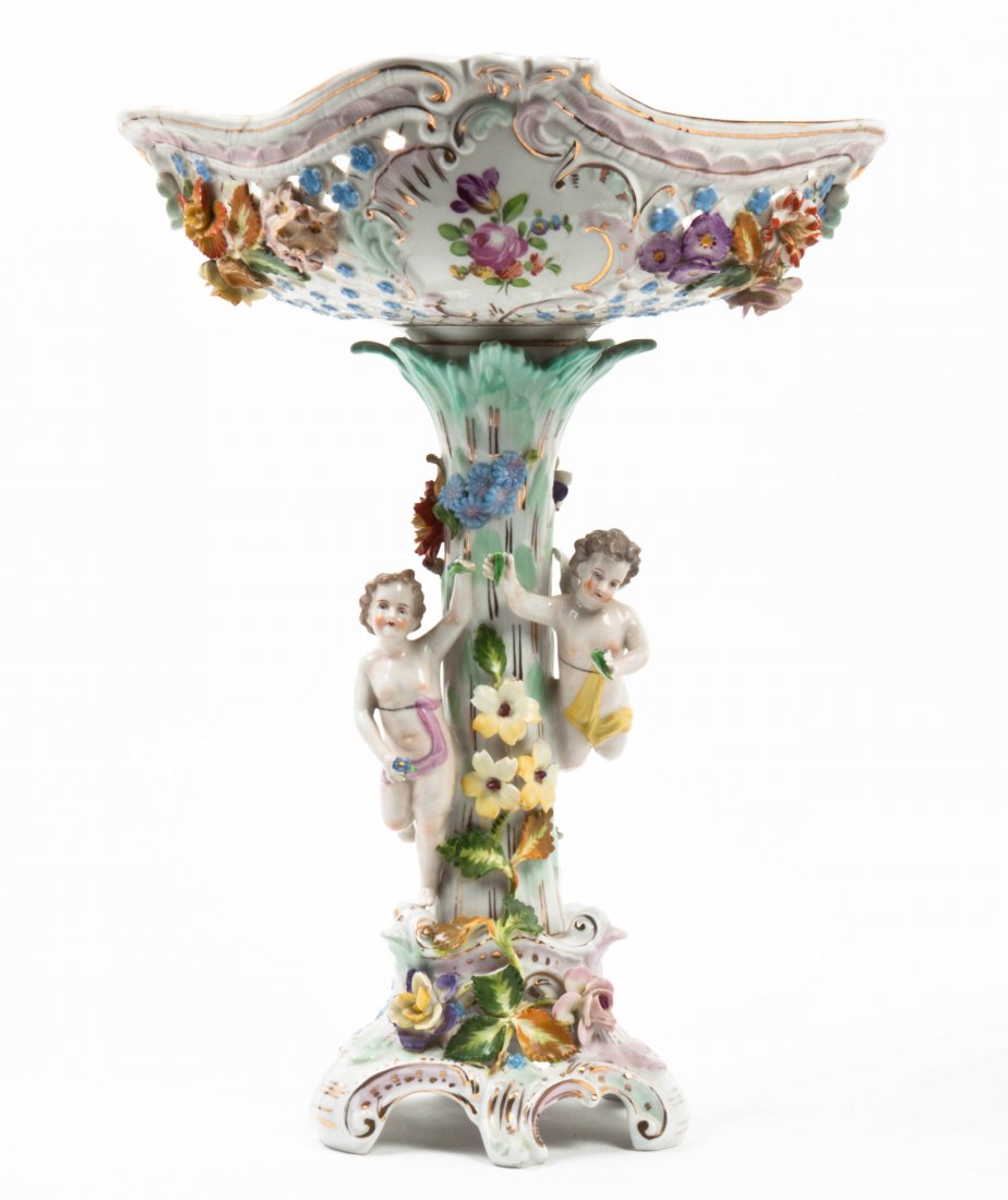 A Dresden Porcelain Figural Compote, Height overall 15 : A Dresden Porcelain Figural Compote, having a pierced floral basket supported by a column modeled with two putti, raised on scrolled feet with gilt highlights throughout. Height overall 15 1/2 inches.