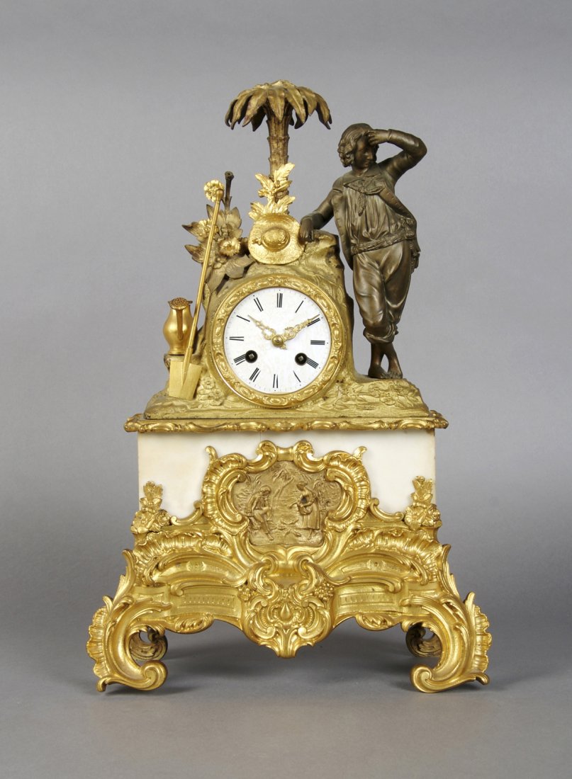 A Louis XVI Style Gilt Metal Figural Mantel Clock, Heig: A Louis XVI Style Gilt Metal Figural Mantel Clock, surmounted with a gardener and his tools beneath a palm tree over the circular dial with Roman numerals, the plinth base set with a relief figural sc