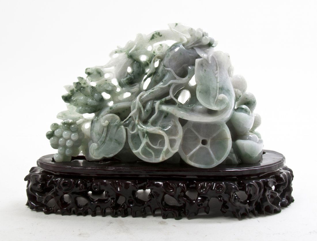 A Chinese Hardstone Carving, Width 11 3/8 inches.: A Chinese Hardstone Carving, of mottled pale green color stone, depicting naturalistic fruits, set on a fitted pierce carved hardwood stand. Width 11 3/8 inches.