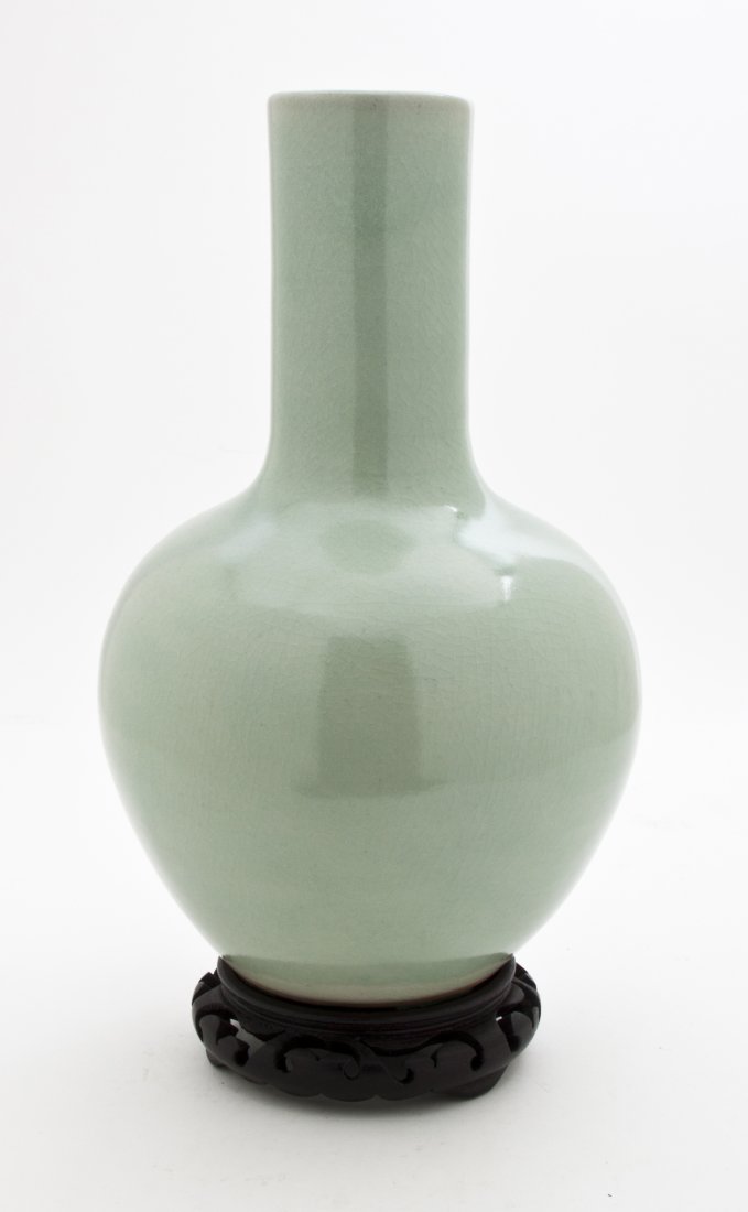 A Celadon Glaze Porcelain Bottle Vase, Height 12 3/4 in: A Celadon Glaze Porcelain Bottle Vase, executed in the Chinese taste, having a cylindrical neck above the ovoid body, with a crackle finish throughout, studio mark and signature to the underside, rais