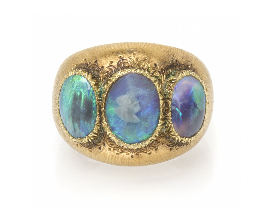 A Vintage 18 Karat Yellow Gold and Opal Ring, Buccellat: A Vintage 18 Karat Yellow Gold and Opal Ring, Buccellati, containing three oval cabochon cut grey opals in textured bezels within the brushed bombe setting. Engraved: BUCCELLATI ITALY 750 (maker's mar
