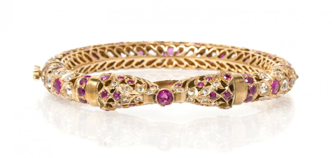A 14 Karat Yellow Gold, Ruby and White Sapphire Bracele: A 14 Karat Yellow Gold, Ruby and White Sapphire Bracelet, in a stylized double elephant Mughal design, containing numerous round brilliant cut rubies and white sapphires, hinged with screw safety. 33.