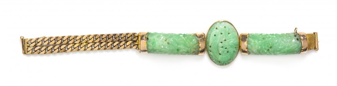 A 14 Karat Yellow Gold and Carved Jade Bracelet, 31.00 : A 14 Karat Yellow Gold and Carved Jade Bracelet, consisting of an central oval jade plaque and two carved rectangular jade sections with gold terminals and a double row of link chain. 31.00 dwts.
